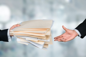 two people passing a bunch of files