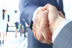prospective employee shake hands with company employee before they negotiate employee benefits