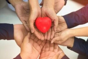 Group of Hands Holding Red Heart after knowing how does group health insurance work