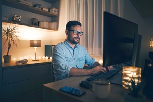 modern young man working remotely from home at night being a retain employees