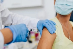 nurse giving shot or vaccine to a patient shoulder