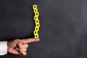 person holding benchmark cubes on finger for benchmarking consulting