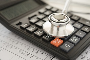 stethoscope and calculator on bills for finance plan or health insurance