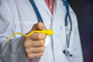 urologist or fertility specialist holds enlarged sperm model in his outstretched hand for fertility insurance coverage