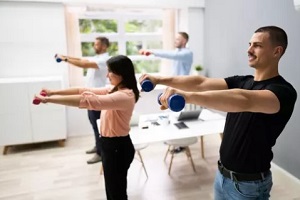 employees with dumbells in office during fitness session