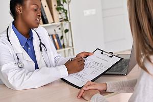 doctor showing insurance claim form consult caucasian patient