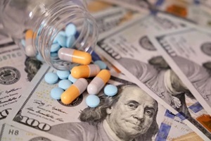 pills and capsules in a bottle on US dollars bills