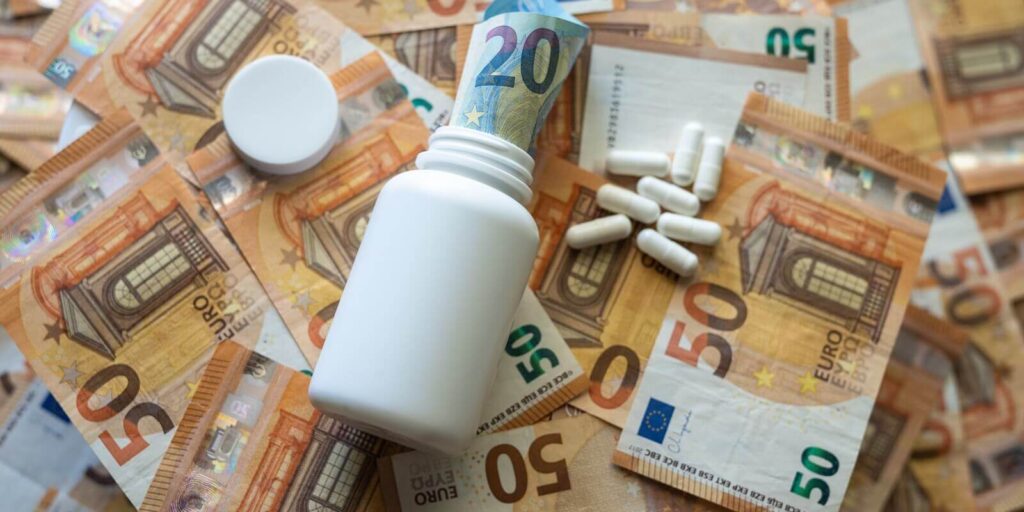 white jar with pills close-up on the background of the euro currency
