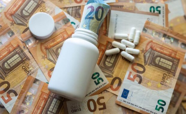 white jar with pills close-up on the background of the euro currency