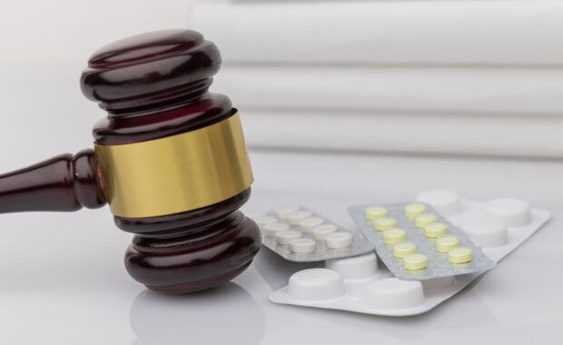 judge gavel and colorful pills on a wooden desk